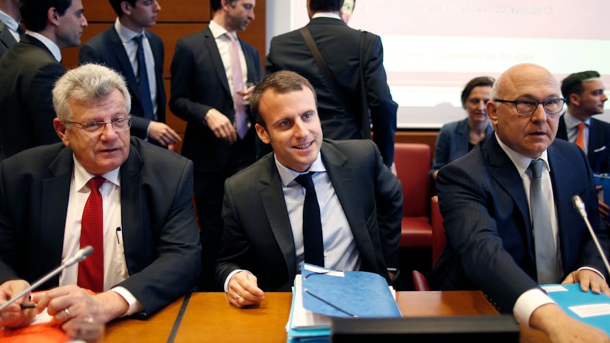 Emmanuel Macron en avril 2015, aux côtés de Christian Eckert (à gauche) et de Michel Sapin, ministre des Finances.