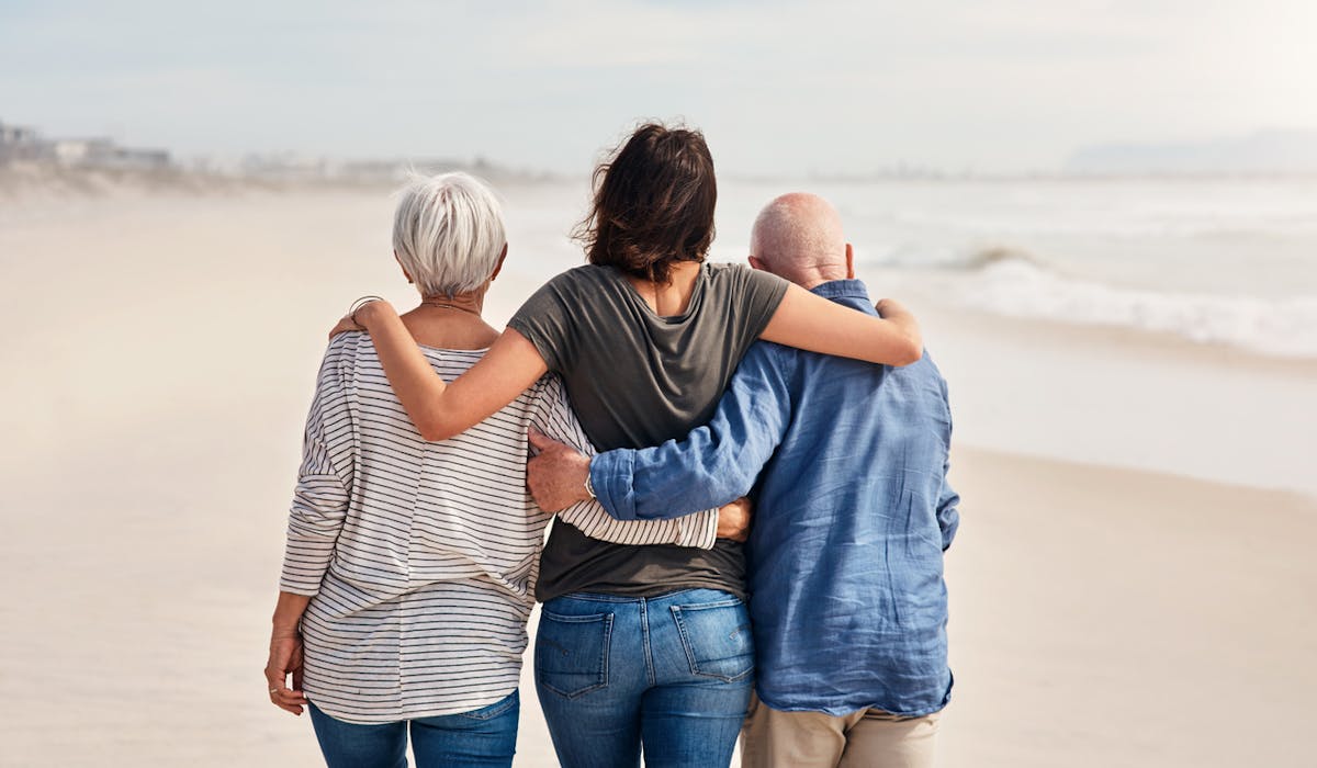 Une jeune adulte entourée par ses parents.