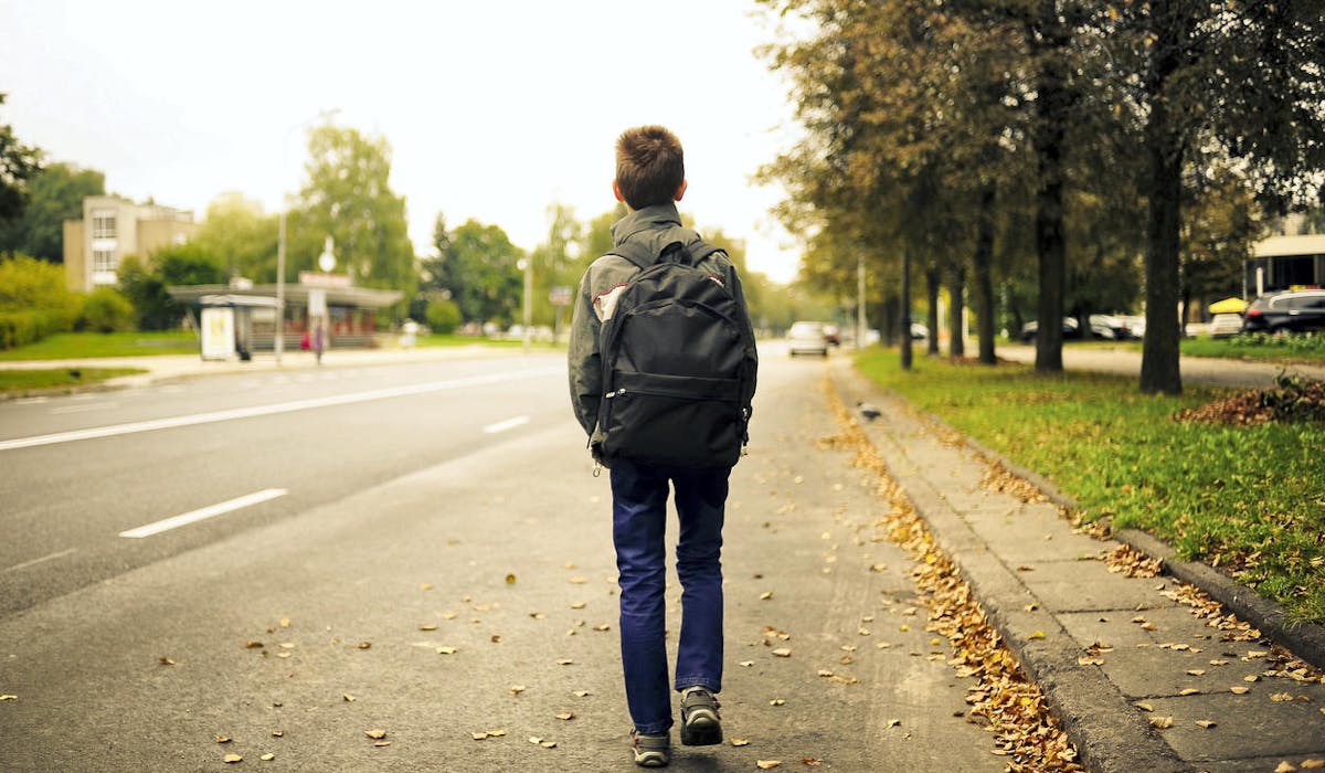 Un enfant tourne le dos à l'école
