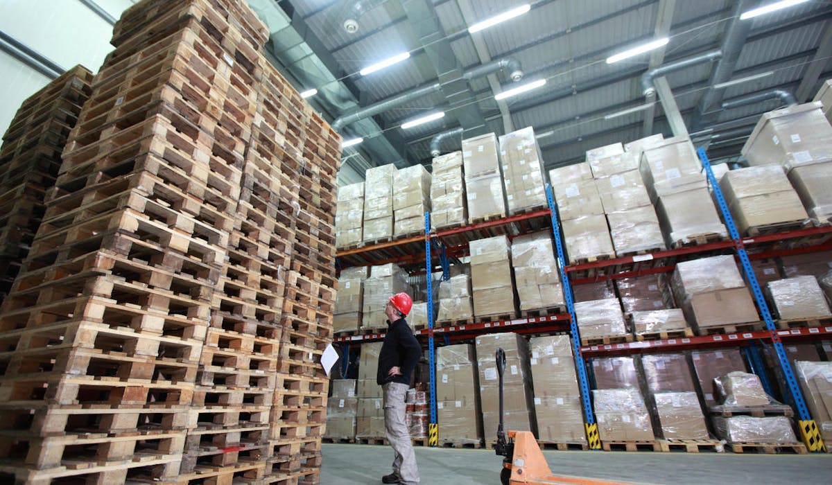 Un entrepôt de stockage et une montagne de palettes, signes d'une activité réduite.