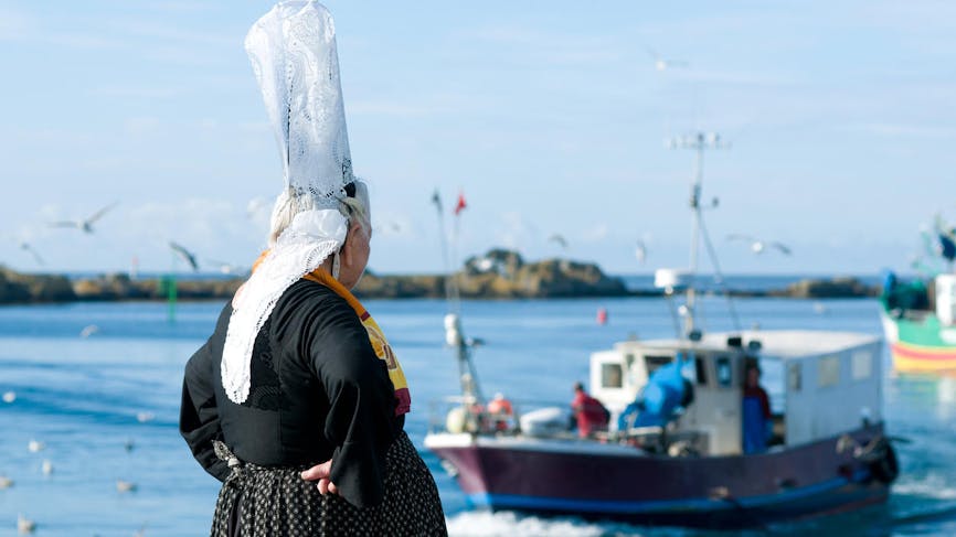 Les marins pêcheurs bretons partent en mer devant une bigoudène