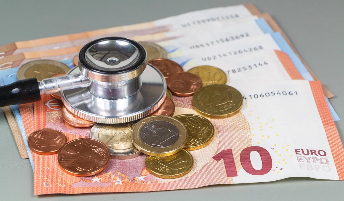 Un stéthoscope, des billets de 1à et 20 € et des pièces de monnaie