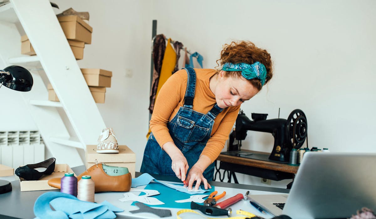Un jeune femme artisan dans son atelier de création de chaussures
