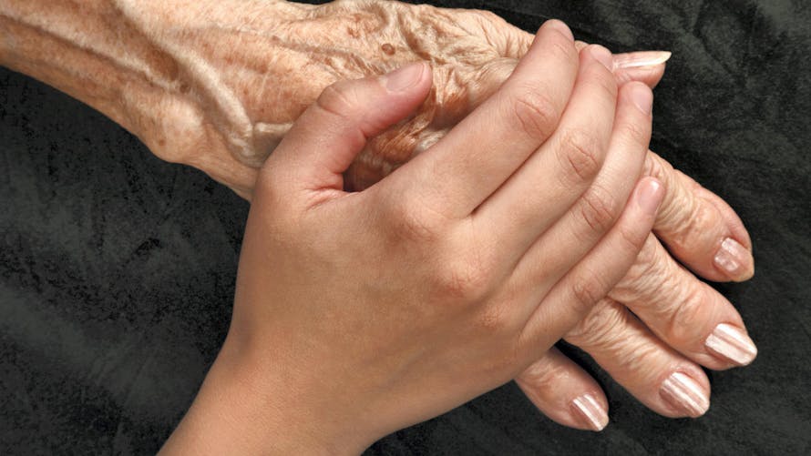 Main d'une jeune femme sur la main d'une vieille femme